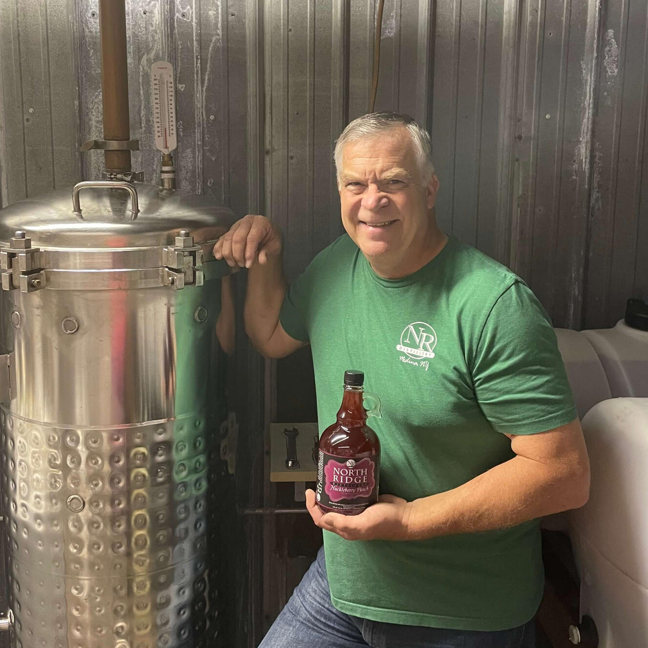 Ray Wendling, the owner and operator of North Ridge Distillery in Medina, NY holding Huckleberry Punch.